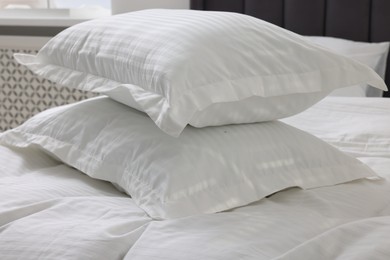 Bed with clean linens and pillows at home