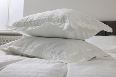 Bed with clean linens and pillows at home