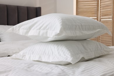 Bed with clean linens and pillows at home