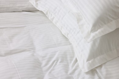 Photo of Bed with clean linens and pillows at home, closeup. Space for text