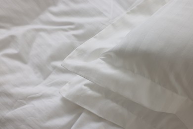 Photo of Bed with clean linens and pillows at home, closeup