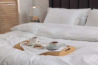 Breakfast tray on bed with beautiful linens indoors