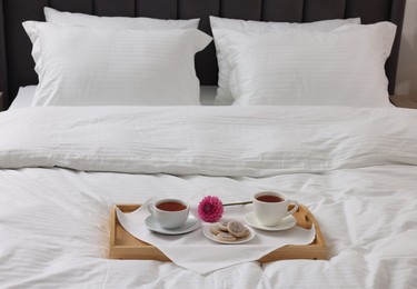 Photo of Breakfast tray on bed with beautiful linens indoors