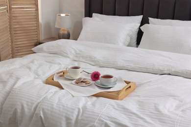 Photo of Breakfast tray on bed with beautiful linens indoors