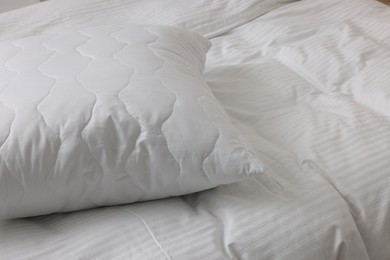 Photo of Bed with clean linens and pillow at home, closeup