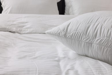 Photo of Bed with clean linens and pillows at home, closeup