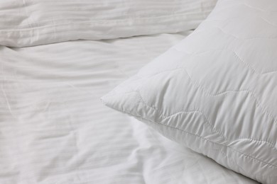 Photo of Bed with clean linens and pillow at home, closeup