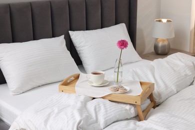 Photo of Breakfast tray on bed with beautiful linens indoors