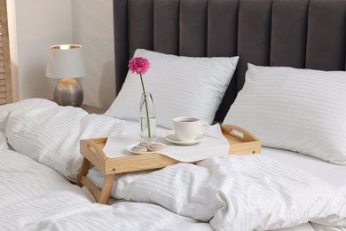 Photo of Breakfast tray on bed with beautiful linens indoors