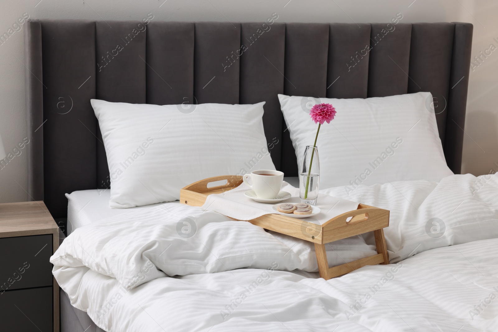 Photo of Breakfast tray on bed with beautiful linens indoors