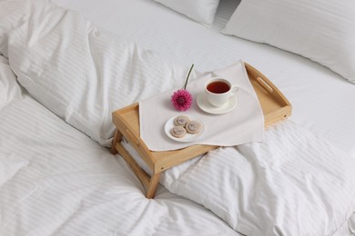 Photo of Breakfast tray on bed with beautiful linens indoors