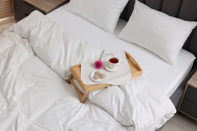 Photo of Breakfast tray on bed with beautiful linens indoors