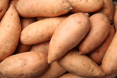 Photo of Fresh raw sweet potatoes as background, top view