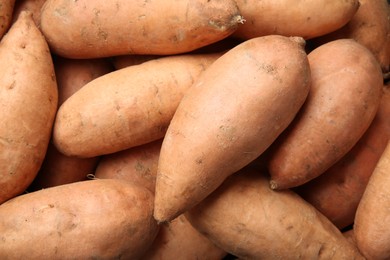 Photo of Fresh raw sweet potatoes as background, top view