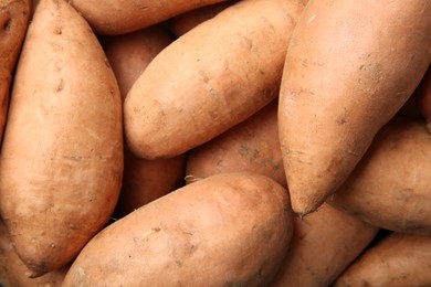 Photo of Fresh raw sweet potatoes as background, top view