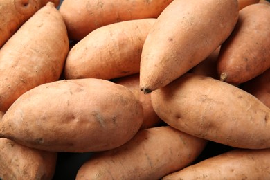 Photo of Fresh raw sweet potatoes as background, closeup