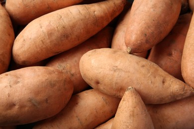 Photo of Fresh raw sweet potatoes as background, top view