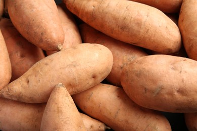 Photo of Fresh raw sweet potatoes as background, top view