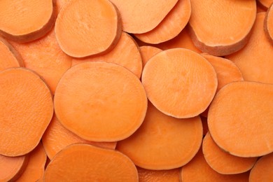 Photo of Slices of raw sweet potatoes as background, top view