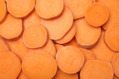 Photo of Slices of raw sweet potatoes as background, top view