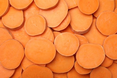 Photo of Slices of raw sweet potatoes as background, top view