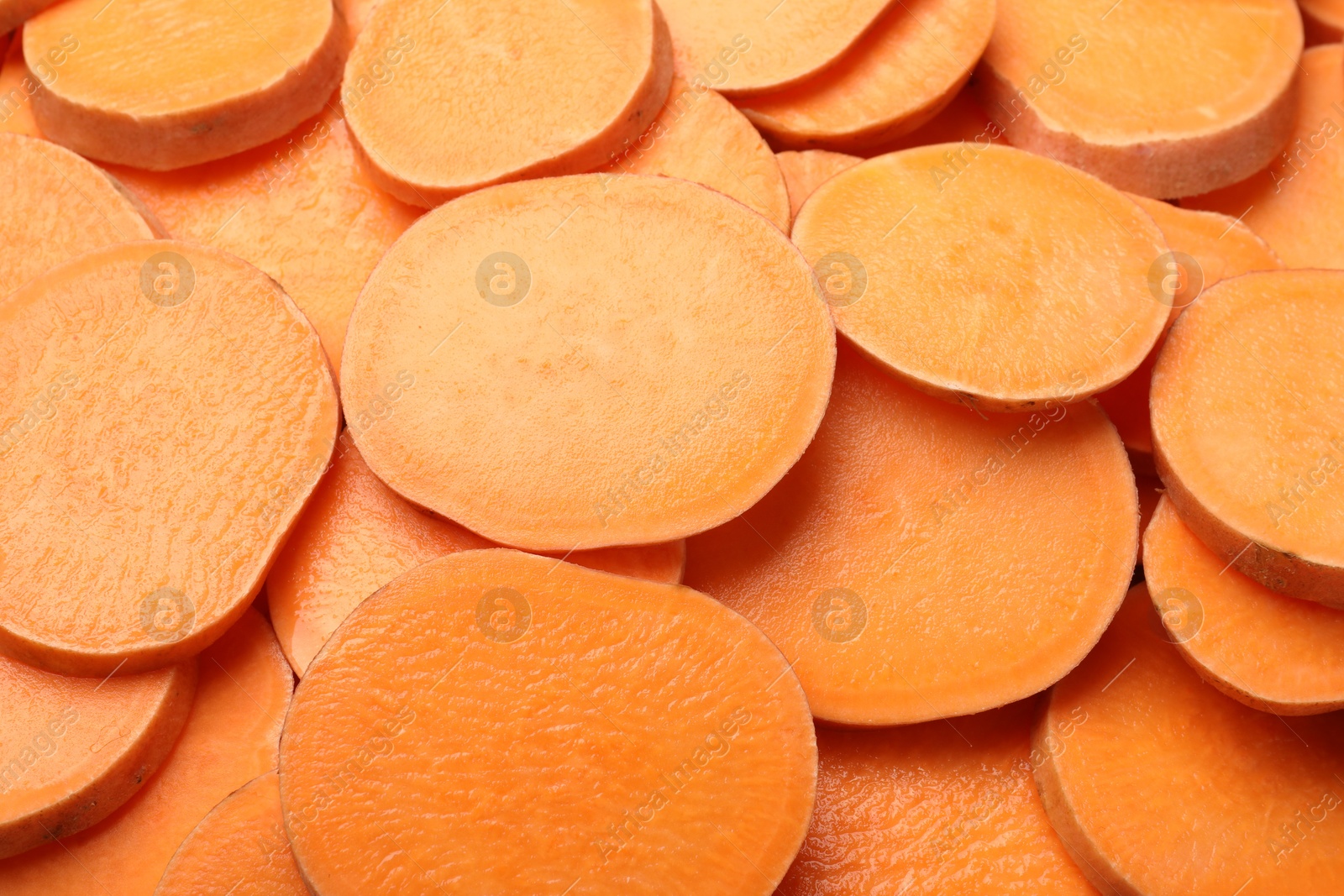 Photo of Slices of raw sweet potatoes as background, closeup