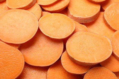 Photo of Slices of raw sweet potatoes as background, closeup