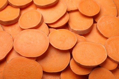 Photo of Slices of raw sweet potatoes as background, closeup