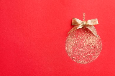 Photo of Christmas ball made with face powder on red background, top view. Space for text