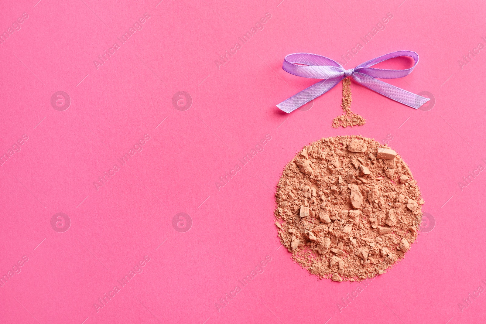 Photo of Christmas ball made with face powder on pink background, top view. Space for text