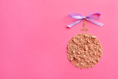 Christmas ball made with face powder on pink background, top view. Space for text