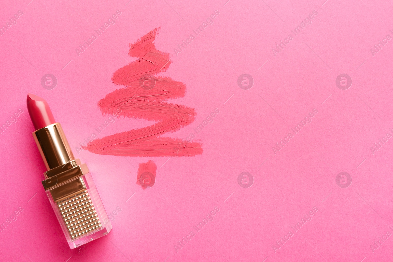 Photo of Christmas tree drawn with lipstick on pink background, top view. Space for text