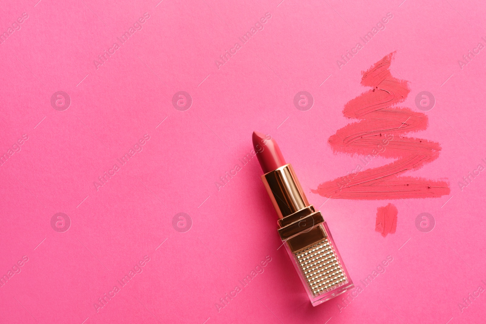 Photo of Christmas tree drawn with lipstick on pink background, top view. Space for text