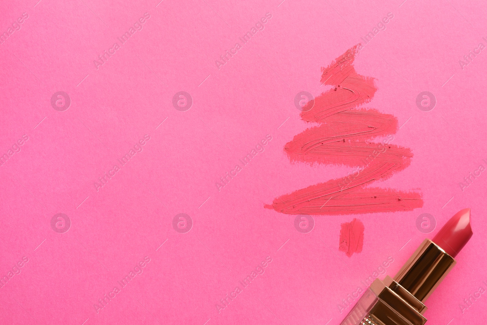 Photo of Christmas tree drawn with lipstick on pink background, top view. Space for text