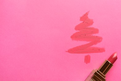 Christmas tree drawn with lipstick on pink background, top view. Space for text