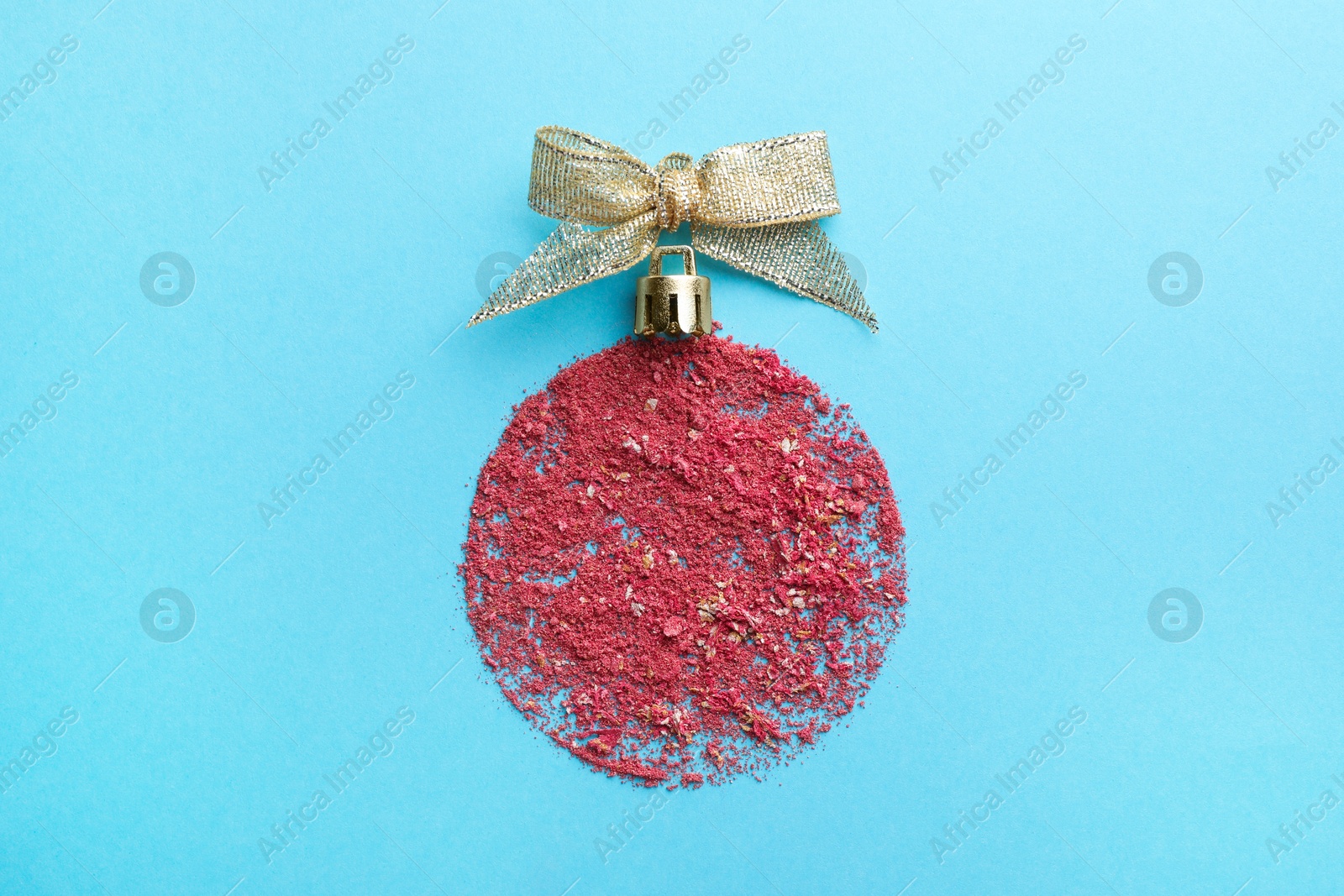 Photo of Christmas ball made with blush on light blue background, top view