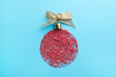 Photo of Christmas ball made with blush on light blue background, top view