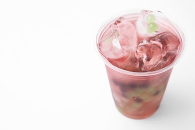 Tasty bubble tea in plastic cup on white background, closeup. Space for text