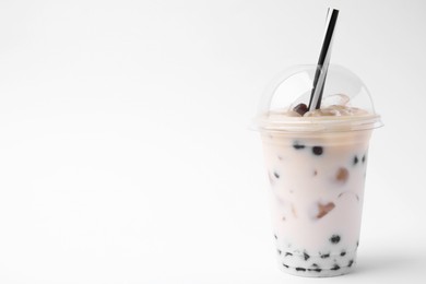 Tasty milk bubble tea in plastic cup on white background, space for text