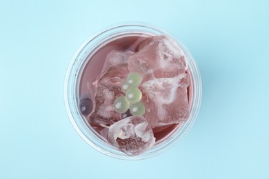 Tasty bubble tea in plastic cup on light blue background, top view