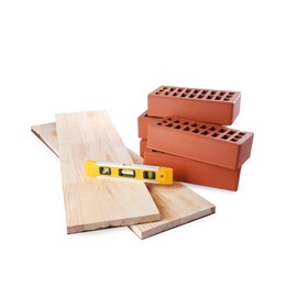 Wooden planks, building level and red bricks isolated on white