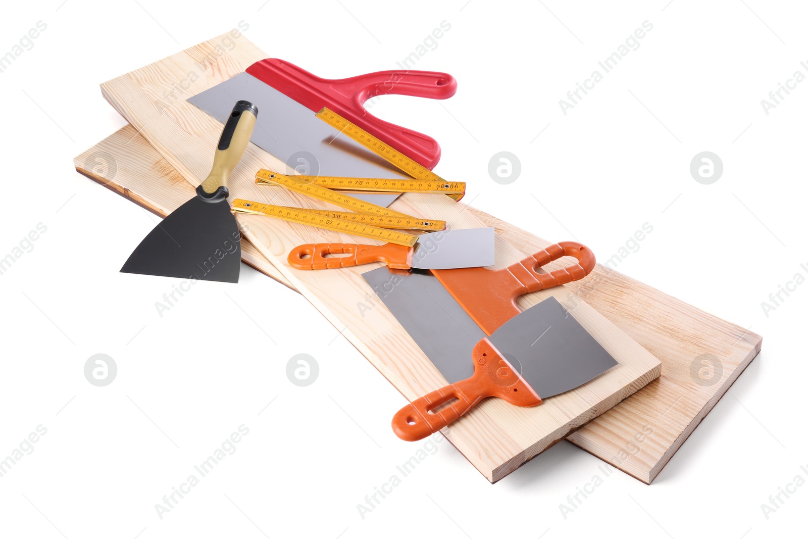 Photo of Wooden planks and putty knives isolated on white. Building material and construction tools