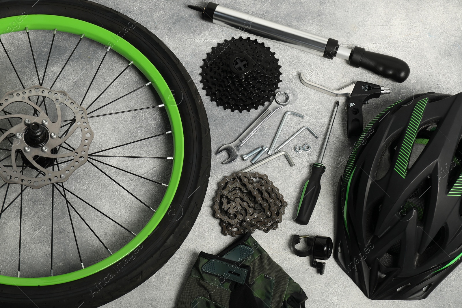 Photo of Parts of bicycle and tools on grey background, flat lay