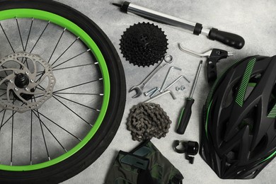 Parts of bicycle and tools on grey background, flat lay