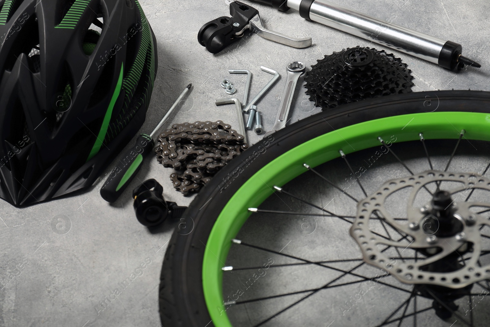 Photo of Parts of bicycle and tools on grey background, closeup