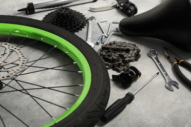 Parts of bicycle and tools on grey background, closeup