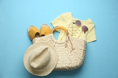 Photo of Flat lay composition with woman's straw bag on light blue background