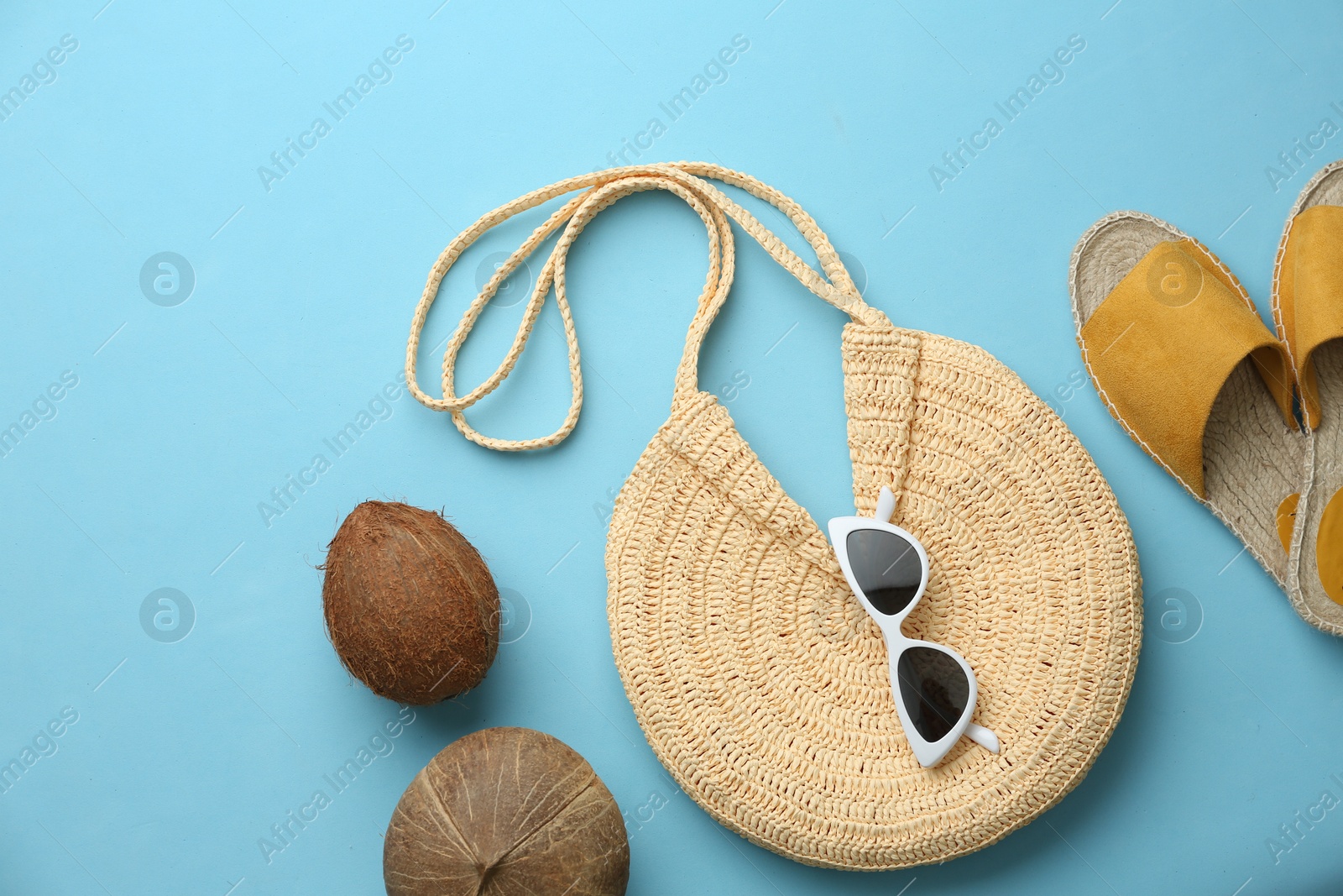 Photo of Flat lay composition with woman's straw bag on light blue background