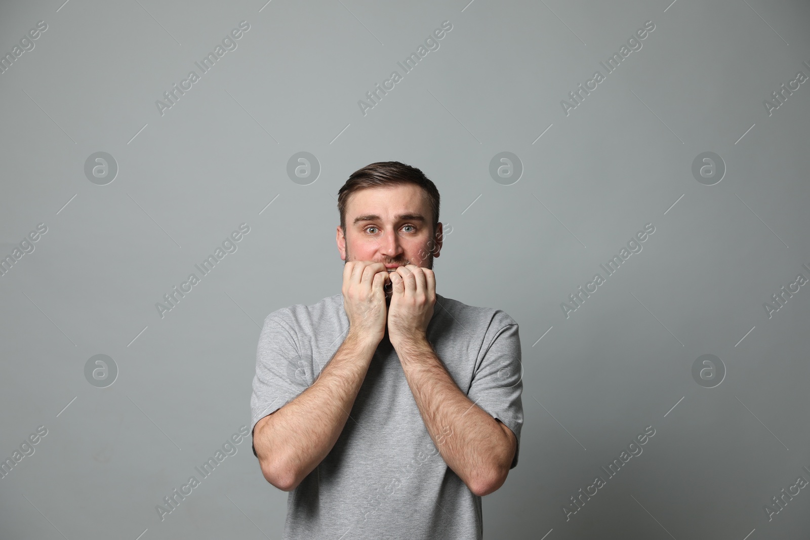 Photo of Young man feeling fear on grey background