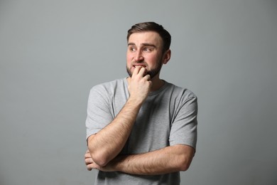 Photo of Young man feeling fear on grey background